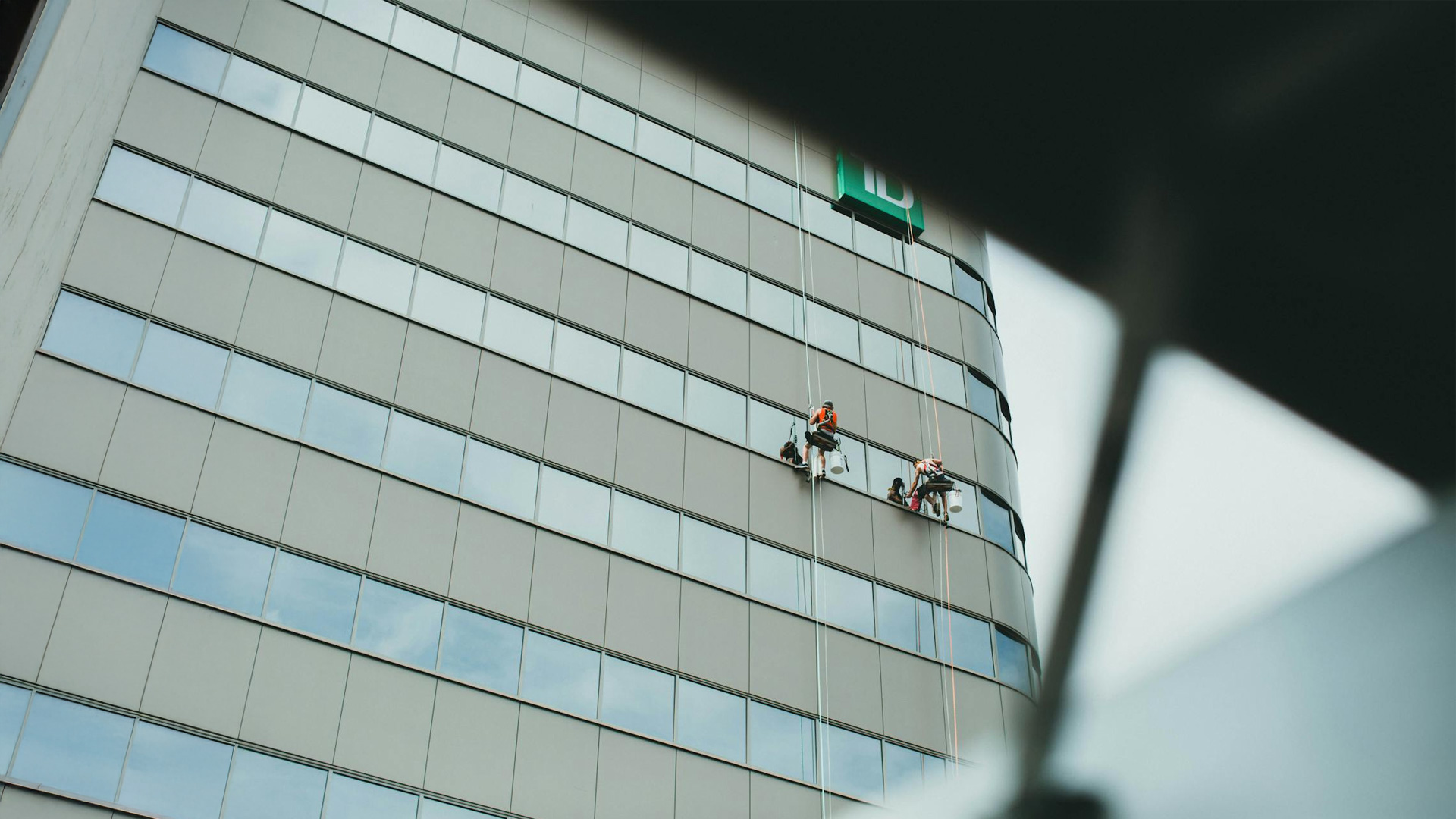 Rope access technician working on a high-rise building facade